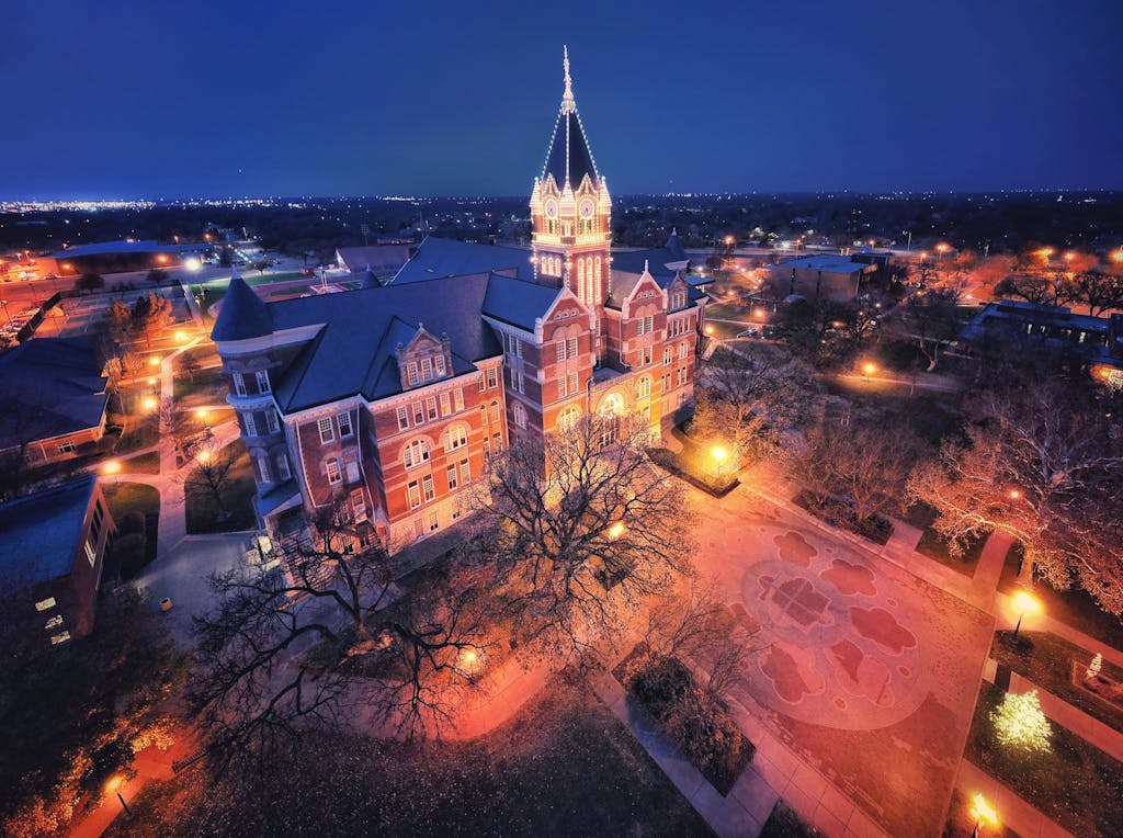 Stunning aerial night view of an illuminated university tower in Wichita, Kansas.