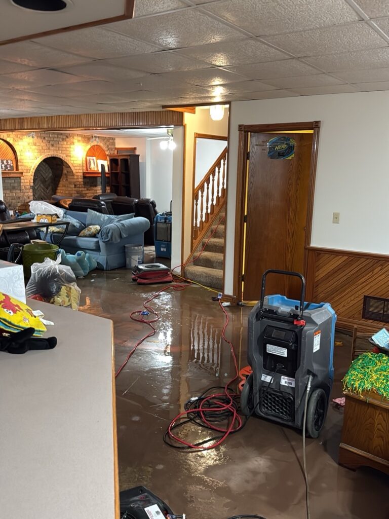 Water on the basement floor and drying equipment at the Gleneagles water damage project in Wichita